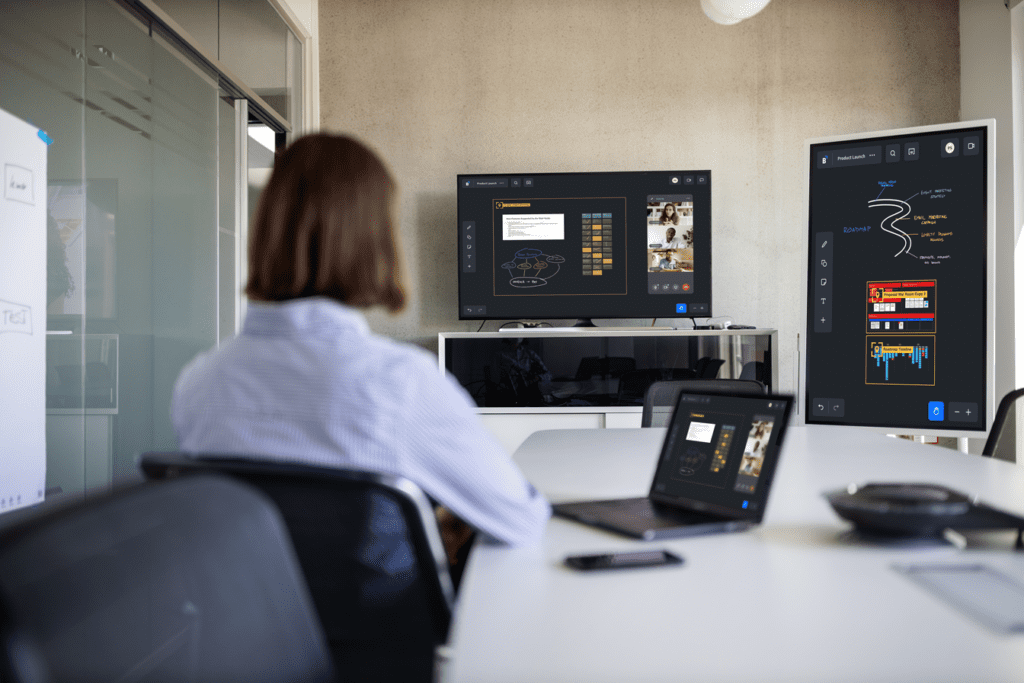 Woman working on three monitors